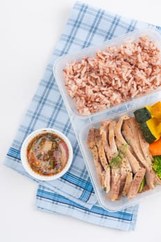 Roasted pork tenderloin with vegetables cooked by clean food concept with brown rice and Northern Thai local sauce on white table
