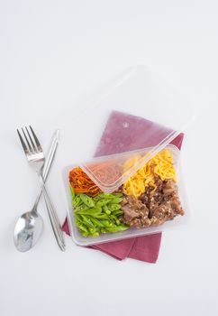 Bibimbub in clean food style. Brown rice with roasted pork, egg, and vegetables on white table