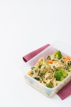 Fettuccine pesto sauce with spinach, grilled fish and vegetables cooked by clean food concept in lunch box on white table