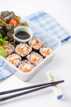 Japanese style brown rice maki with grilled chicken, grilled pork, and grilled tofu cooked by clean food concept in lunch box on white table