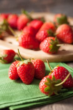 Strawberries on wood background in vintage style with low key scene.