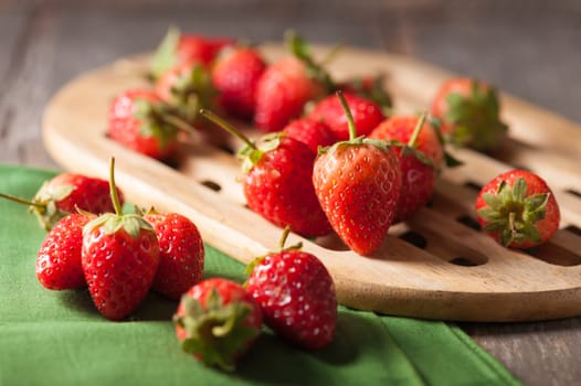 Strawberries on wood background in vintage style with low key scene.