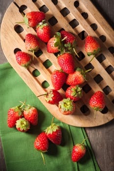 Strawberries on wood background in vintage style with low key scene.