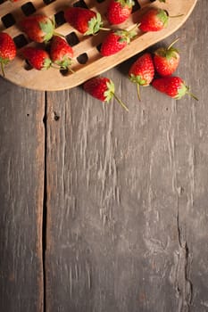 Strawberries on wood background in vintage style with low key scene.