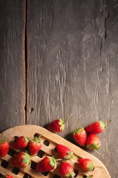 Strawberries on wood background in vintage style with low key scene.