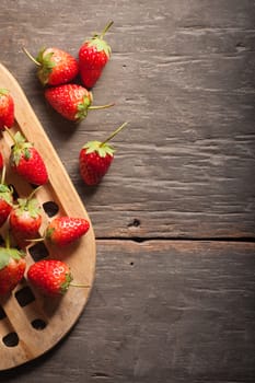 Strawberries on wood background in vintage style with low key scene.