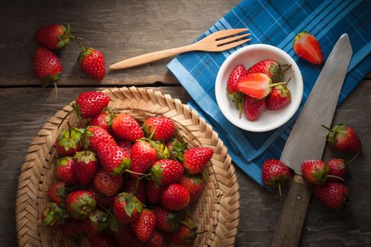 Strawberries on wood background in vintage style with low key scene.