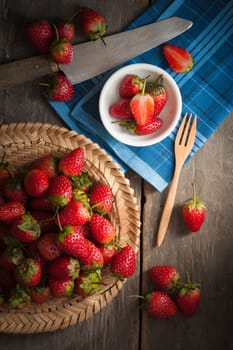 Strawberries on wood background in vintage style with low key scene.