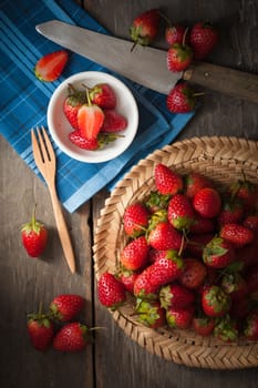 Strawberries on wood background in vintage style with low key scene.