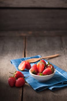 Strawberries on wood background in vintage style with low key scene.