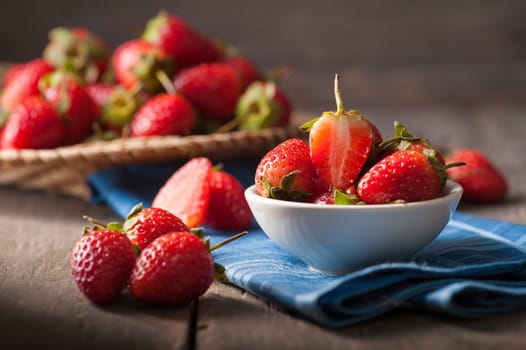 Strawberries on wood background in vintage style with low key scene.