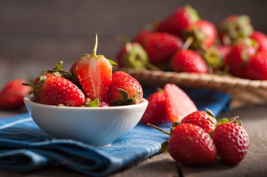 Strawberries on wood background in vintage style with low key scene.