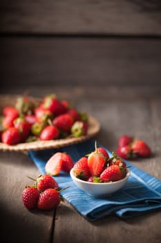Strawberries on wood background in vintage style with low key scene.