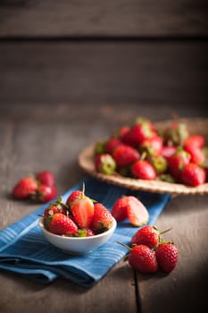 Strawberries on wood background in vintage style with low key scene.
