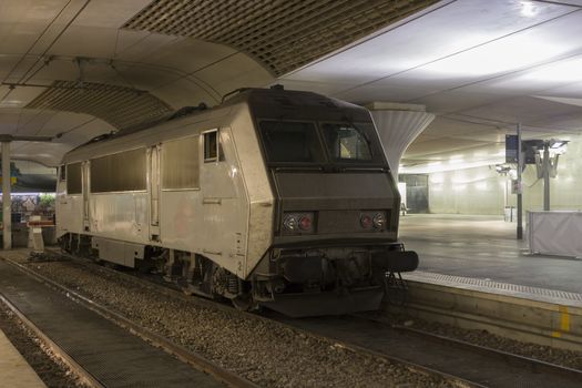 Metal modern train, which stands on railroad.