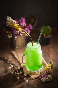 Green frozen cocktail on wood table in vintage stye with low key scene
