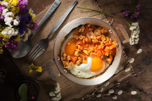 Vietnamese style fried egg in metal pan with white pork and onion on wood table in vintage style with low key scene