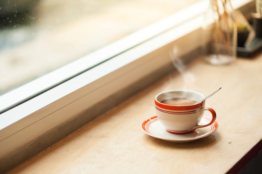 Milk coffee in coffee cup on wood bar with morning scene