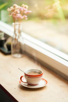 Milk coffee in coffee cup on wood bar with morning scene