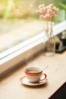 Milk coffee in coffee cup on wood bar with morning scene