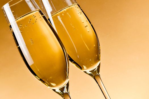 filled glasses of champagne on golden background