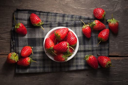 Strawberries on wood background in vintage style with low key scene.