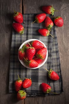 Strawberries on wood background in vintage style with low key scene.