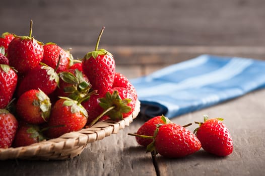 Strawberries on wood background in vintage style with low key scene.