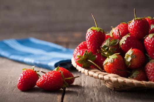 Strawberries on wood background in vintage style with low key scene.