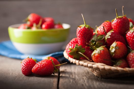 Strawberries on wood background in vintage style with low key scene.