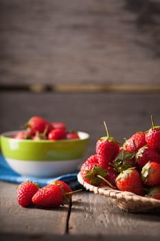 Strawberries on wood background in vintage style with low key scene.