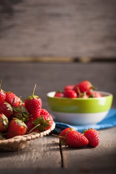 Strawberries on wood background in vintage style with low key scene.