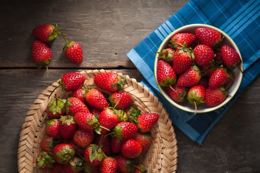Strawberries on wood background in vintage style with low key scene.
