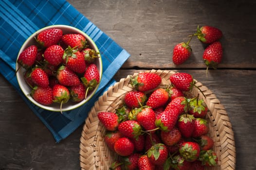 Strawberries on wood background in vintage style with low key scene.