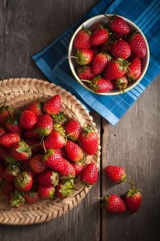 Strawberries on wood background in vintage style with low key scene.