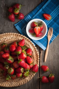 Strawberries on wood background in vintage style with low key scene.