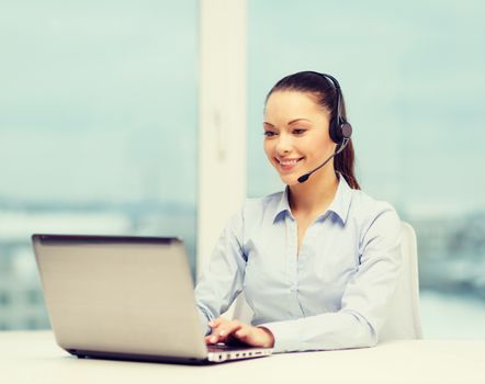 business, communication and call center concept - friendly female helpline operator with headphones and laptop computer