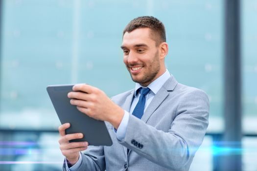 business, education, technology and people concept - smiling businessman working with tablet pc computer on city street