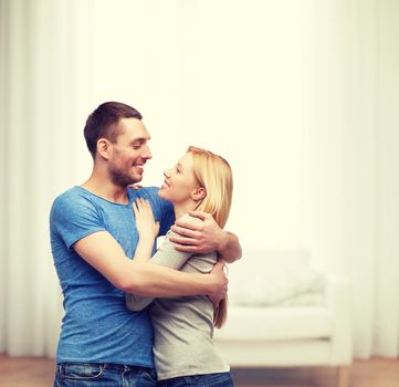 love and family concept - smiling couple hugging and looking at each other