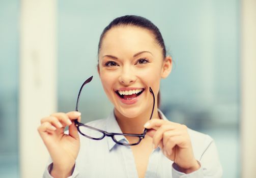 business and education concept - laughing businesswoman with eyeglasses