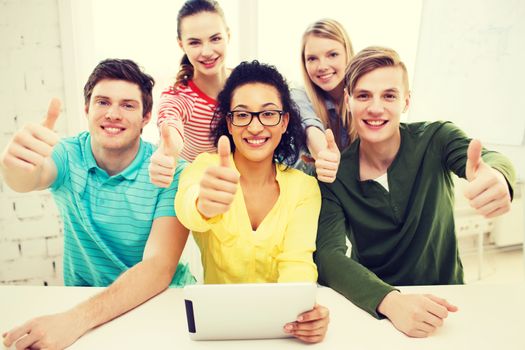 education, technology and college concept - five smiling students with tablet pc computer at school and showing thumbs up