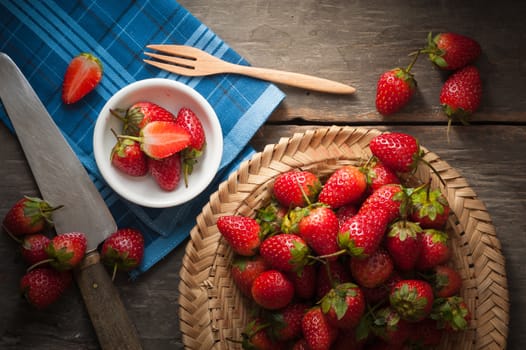 Strawberries on wood background in vintage style with low key scene.