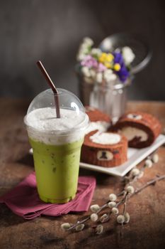 Iced green tea latte on wood table with low key scene