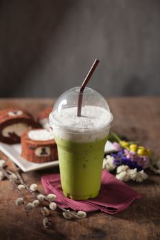 Iced green tea latte on wood table with low key scene