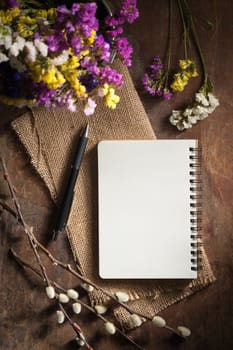 Small notepad with pen on rustic wood background with film filter effect