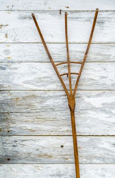 Wooden pitchfork on a white wall