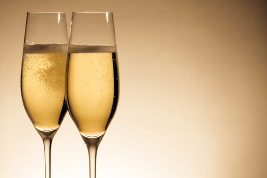 two glasses of champagne with golden bubbles and space for text