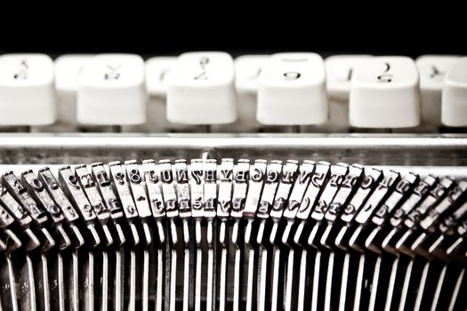 detail of type bars and white buttons of typewriter on black background