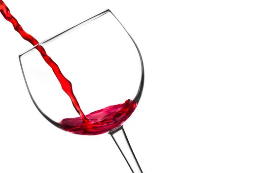red wine pouring into glass tilted with space for text on a white background
