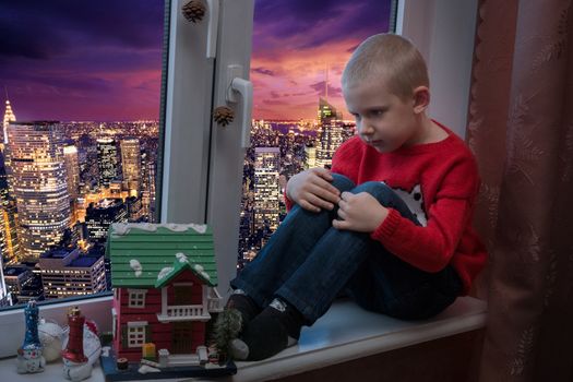The photo depicts a boy on a windowsill